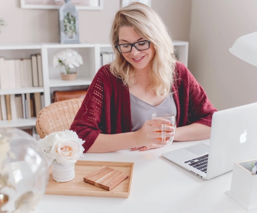 Woman typing on laptop and writing on a notebook